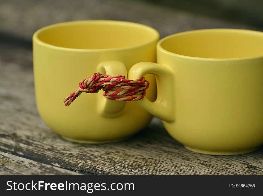 A pair of cups tied together by the handles. A pair of cups tied together by the handles.