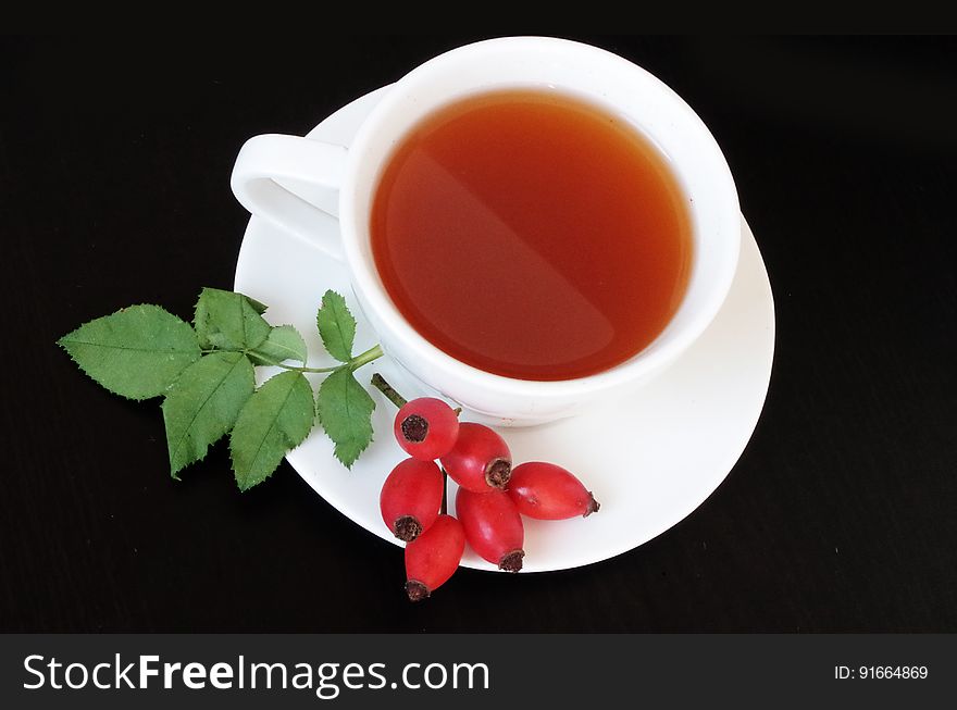 Cup of rosehip tea isolated on black.