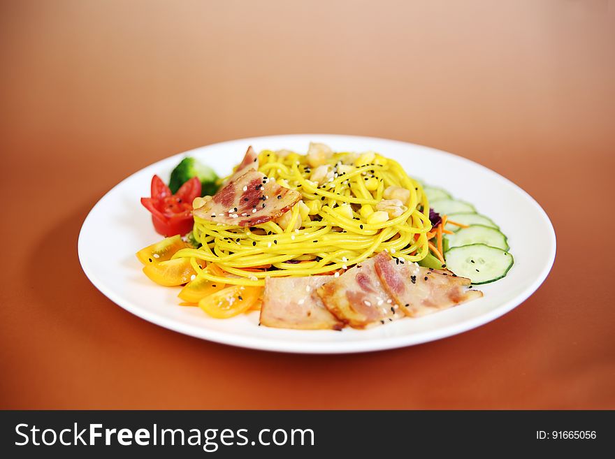 A plate of pasta with vegetables and meat.