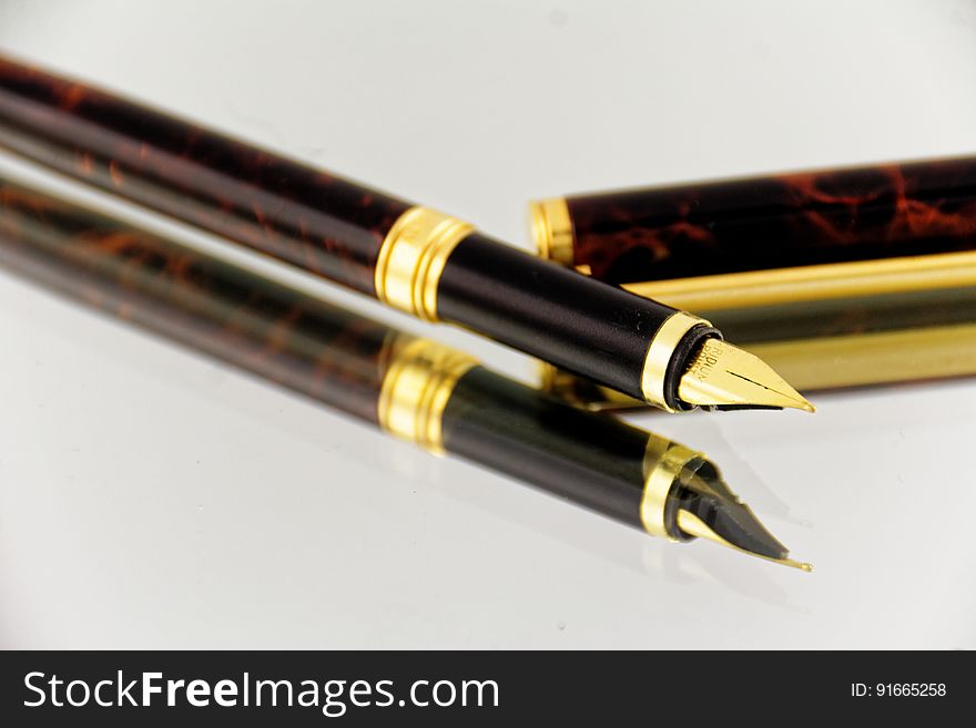 Elegant Fountain Pen Reflecting On Glass Surface
