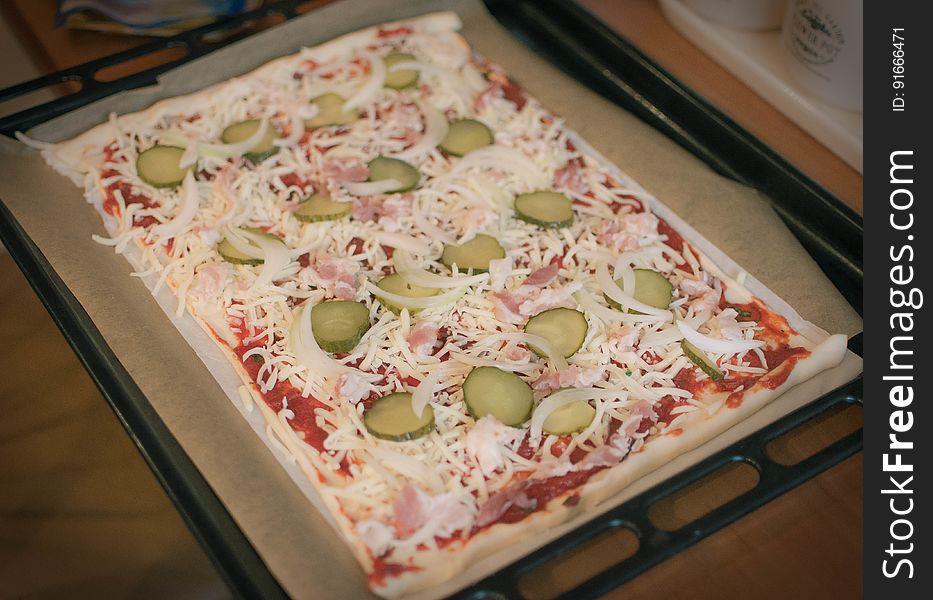 A close up of a homemade pizza on a baking tray.