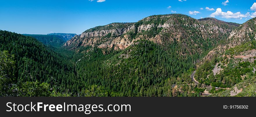 Oak Creek Canyon is a gorge carved into the edge of the Mogollon Rim of the Colorado Plateau along the Oak Creek Fault. Tectonic forces shifting the land to either side of the fault and subsequent erosion by Oak Creek have created a spectacular canyon where the geologic history of this area is an open book. The Canyon is approximately 12 miles long. Oak Creek flows year-round along the bottom of the Canyon, providing water for plants and wildlife, as well as fishing and swimming opportunities. Oak Creek continues on through Sedona, Arizona, meeting up with the Verde River southeast of Cottonwood, Arizona. The depth of the Canyon ranges from 800 to 2000 feet, with trails providing access from the Canyon’s bottom up to the 6500-foot eastern rim and 7200-foot western rim. Some of these trails follow historic routes early Oak Creek Canyon settlers used to access the top of the plateau in the days before the road was built. Trails on the west side of the Canyon head into Red Rock-Secret Mountain Wilderness. Multi-photo panorama by Deborah Lee Soltesz, June 12, 2015. Credit U.S. Forest Service Coconino National Forest. Learn more about Oak Creek Canyon and the Coconino National Forest.