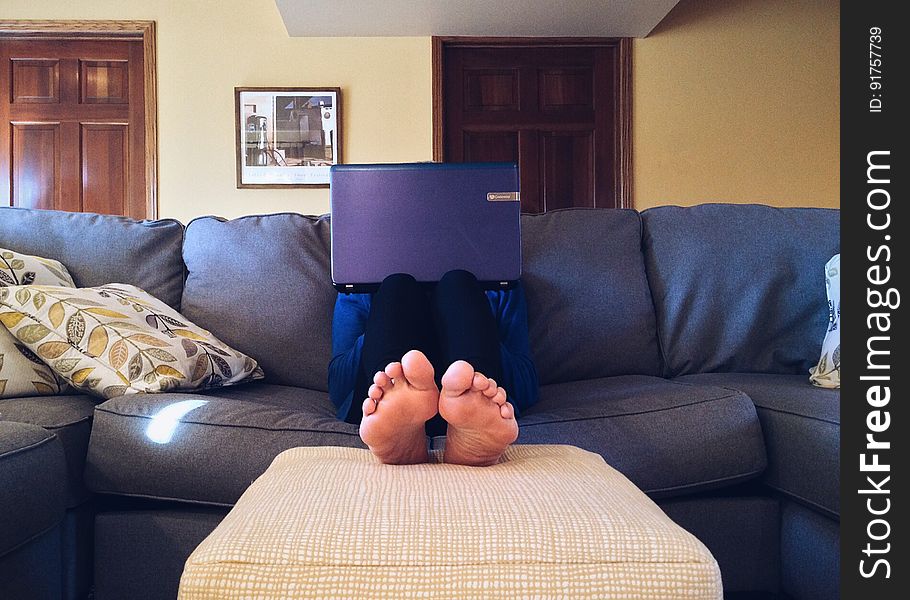 A person sitting on the sofa with a laptop computer. A person sitting on the sofa with a laptop computer.
