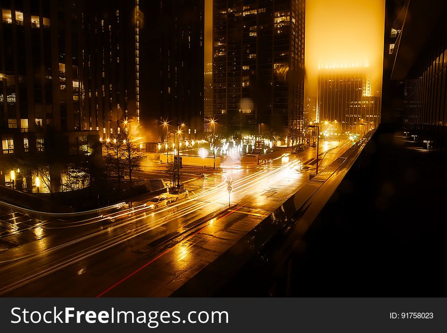 A view of the streets of a city at night with traffic. A view of the streets of a city at night with traffic.