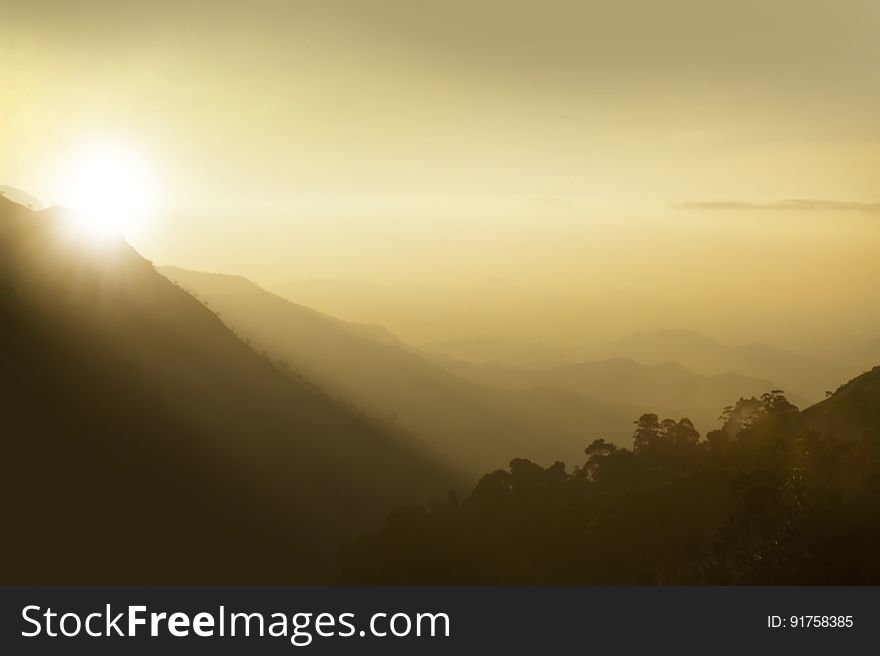 A view of hazy mountains at sunset. A view of hazy mountains at sunset.