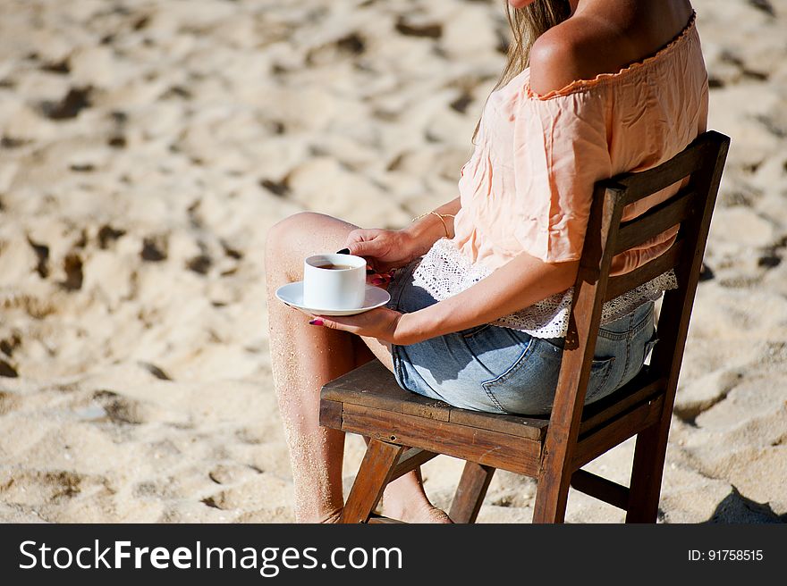 Girl drinking coffee on beach