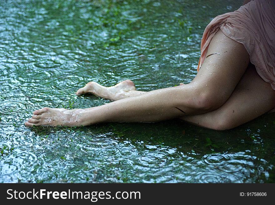 Woman&#x27;s hips and legs lying in green mud