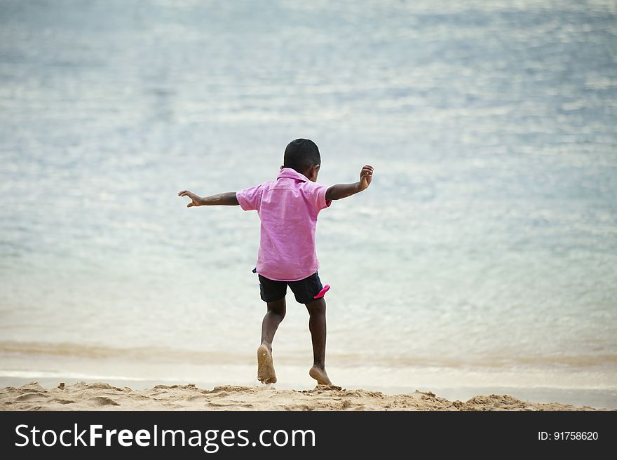 A young boy playing on the beach. A young boy playing on the beach.