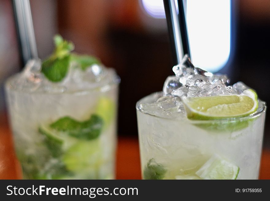 Two iced cocktails garnished with mint and lime. Two iced cocktails garnished with mint and lime.