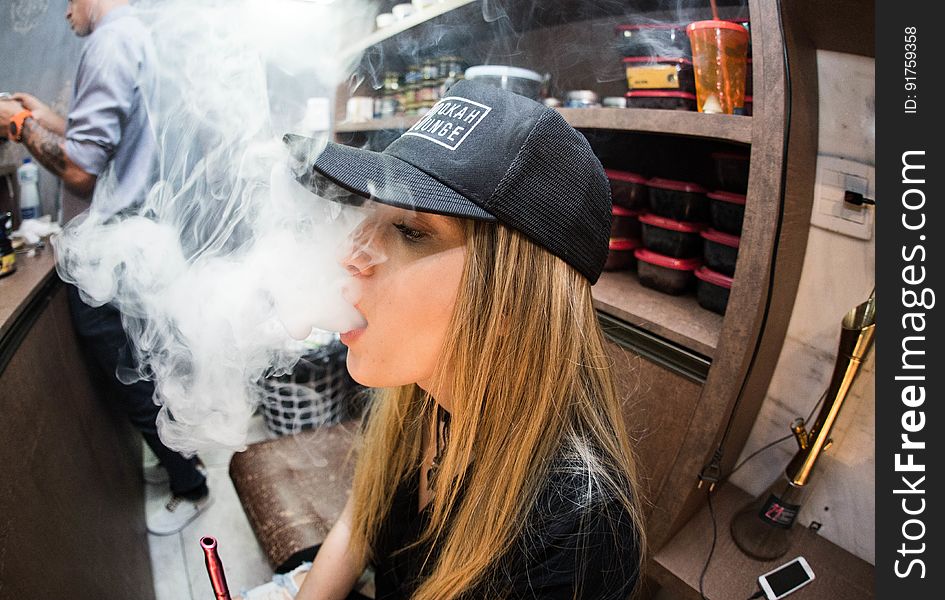 Young woman vaping in restaurant