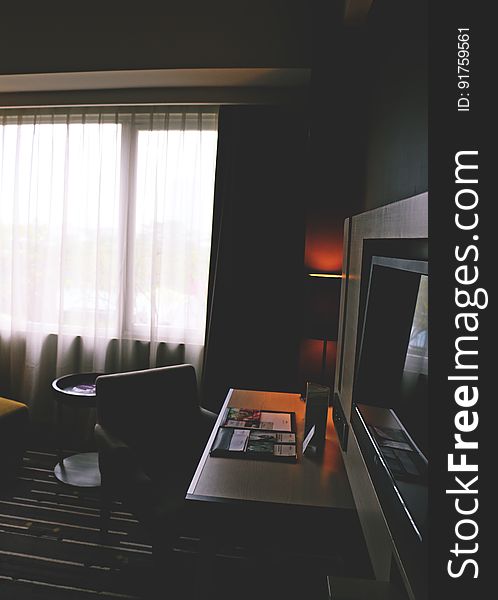 Modern hotel room with tv and desk.