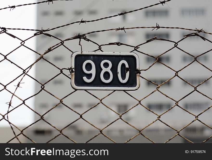 Barbed wire fence with number plate on it. Barbed wire fence with number plate on it.