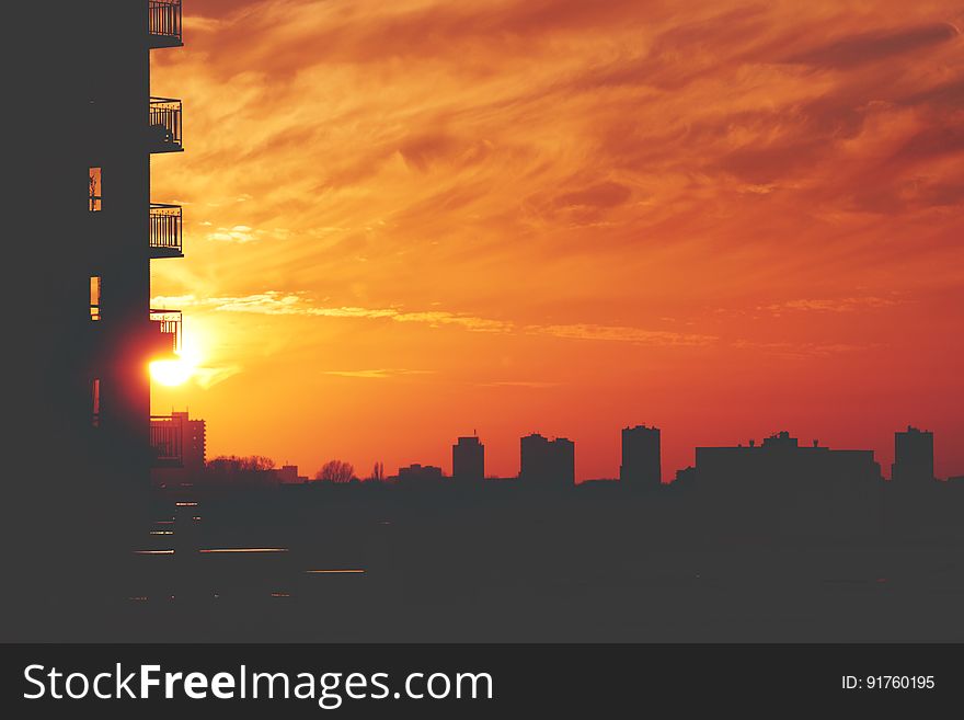 An urban sunset with apartment silhouettes.
