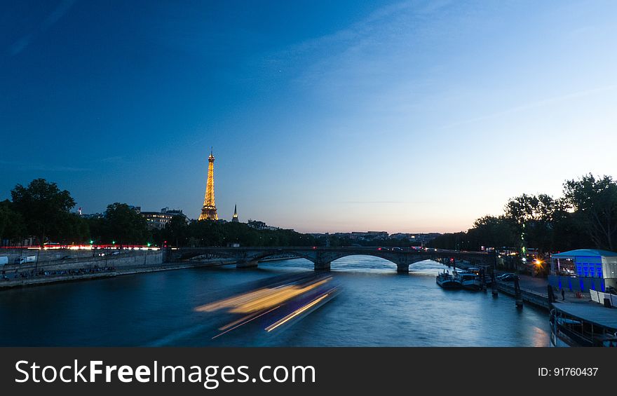 A night view of Paris, France, with boats on the river Seine.