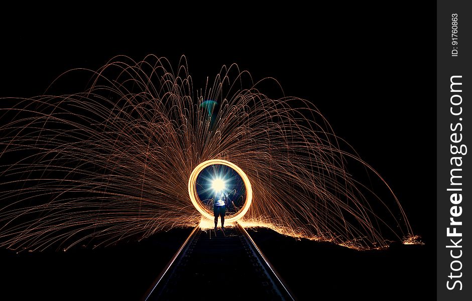 A long exposure of burning steel wool spun around at night. A long exposure of burning steel wool spun around at night.