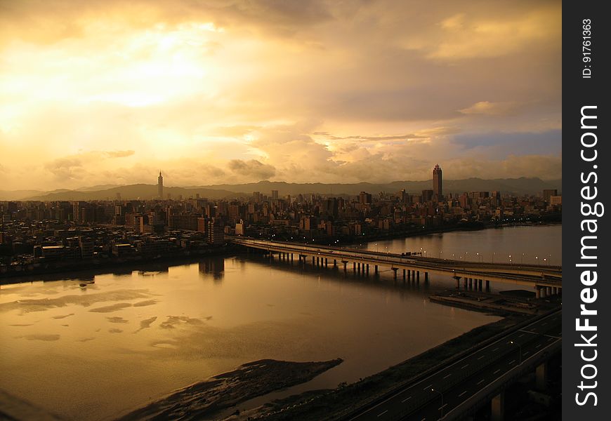 A sunset over a city with river and a bridge. A sunset over a city with river and a bridge.