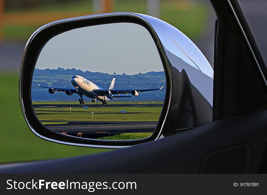 White Airplane Reflection on Car Side Mirror