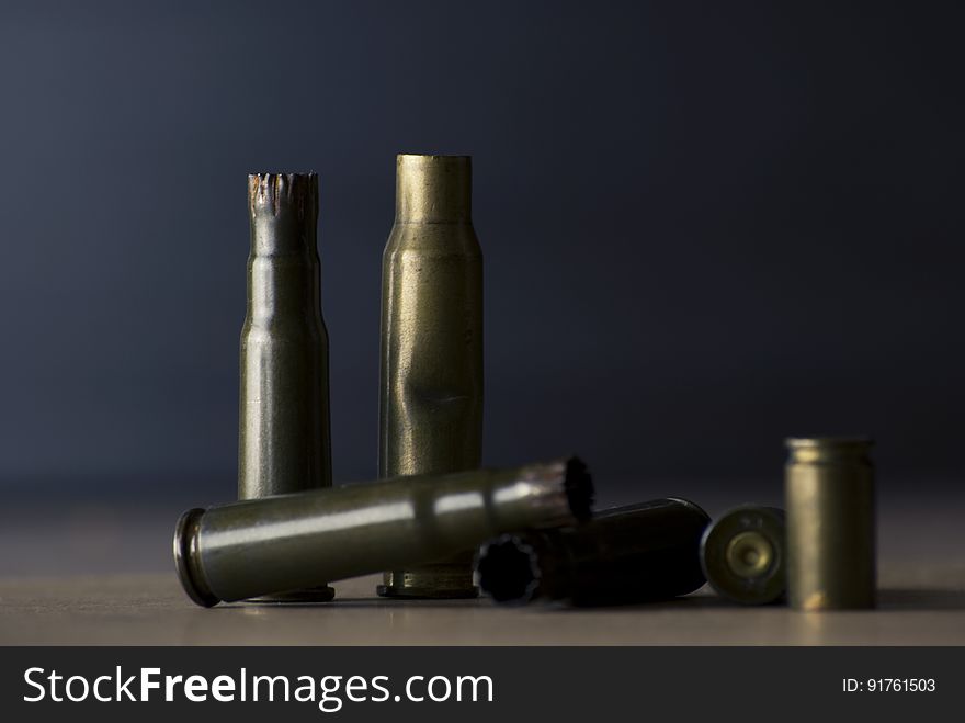 Empty Bullet Shells on Brown Surface