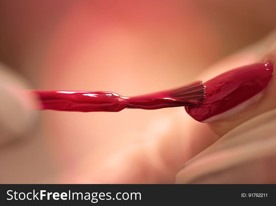 Woman hands receiving a manicure in beauty salon. Nail filing. Close up, selective focus.