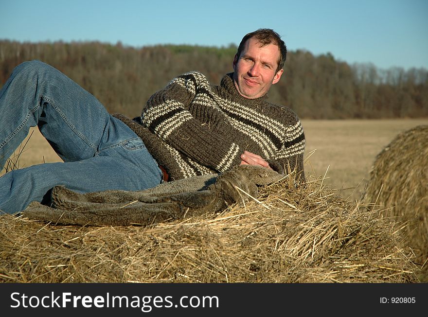 Man having rest on haystack in late autumn