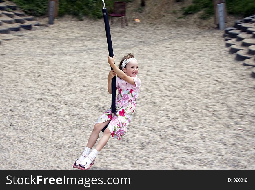 Young girl swinging on a playground. Young girl swinging on a playground