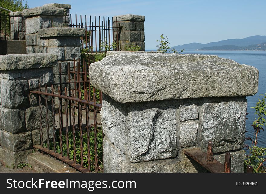 A stone and iron fence overlooking the ocean. A stone and iron fence overlooking the ocean.