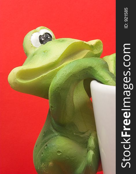Frog climbing coffee cup. Frog climbing coffee cup