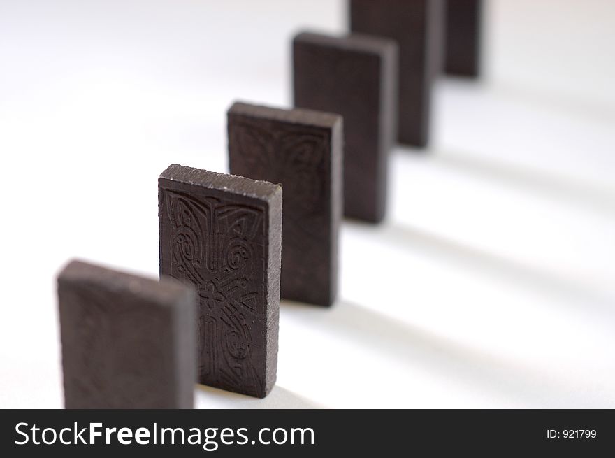 A row of black dominoes casting a shadow on white. A row of black dominoes casting a shadow on white