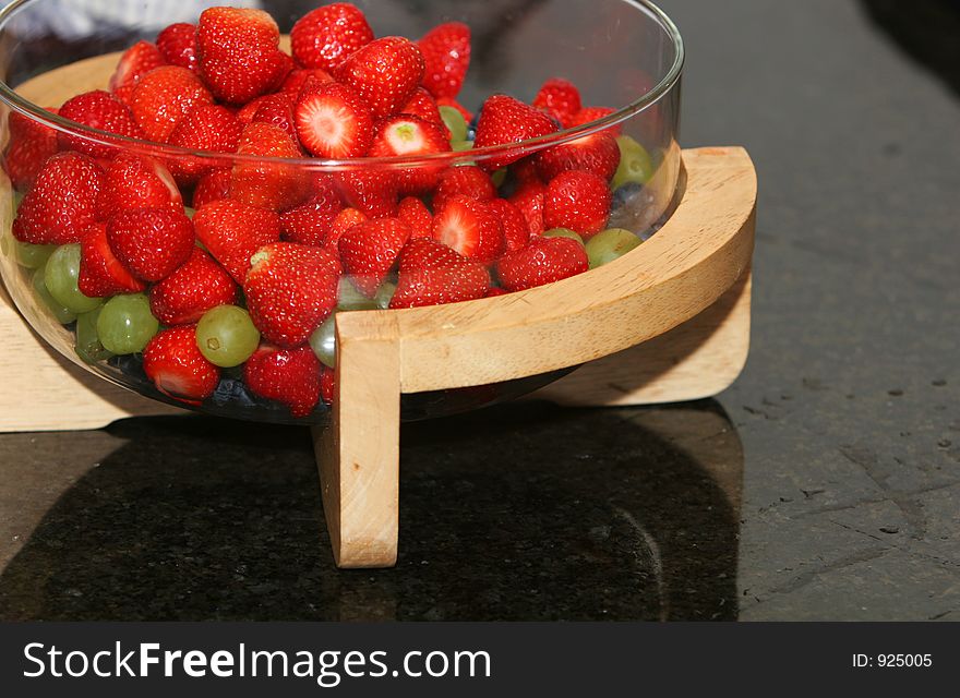 A bowl of fresh berries, strawberries, blueberries, grapes, all ready to be served as dessert. A bowl of fresh berries, strawberries, blueberries, grapes, all ready to be served as dessert.