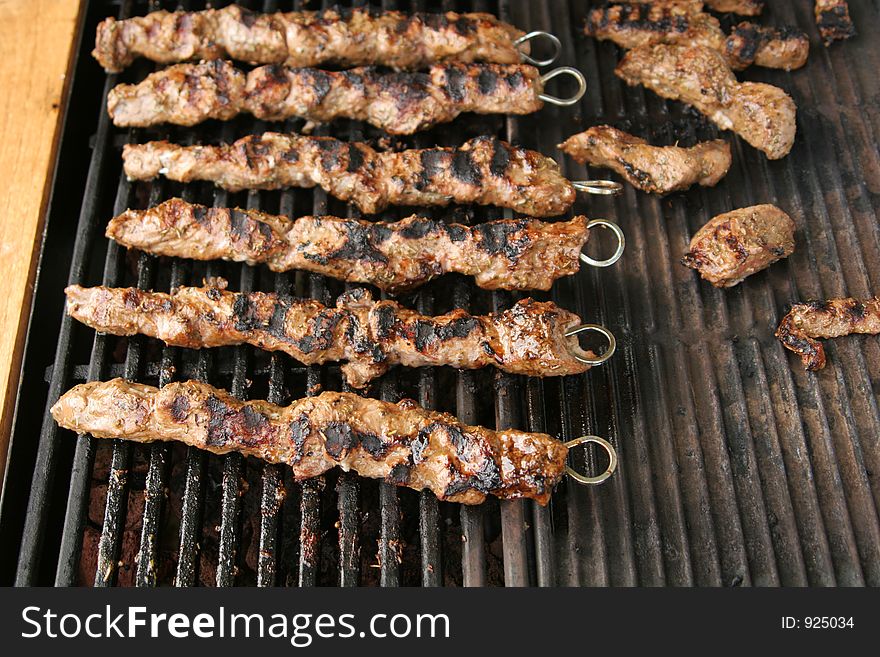 Pork meat sticks being grilled on a barbecue. Pork meat sticks being grilled on a barbecue