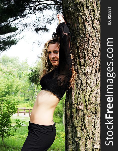 Woman in the park leaning on a tree