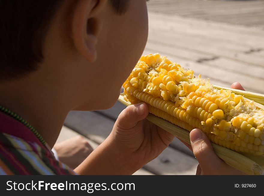 Child eating corn at the park. Child eating corn at the park