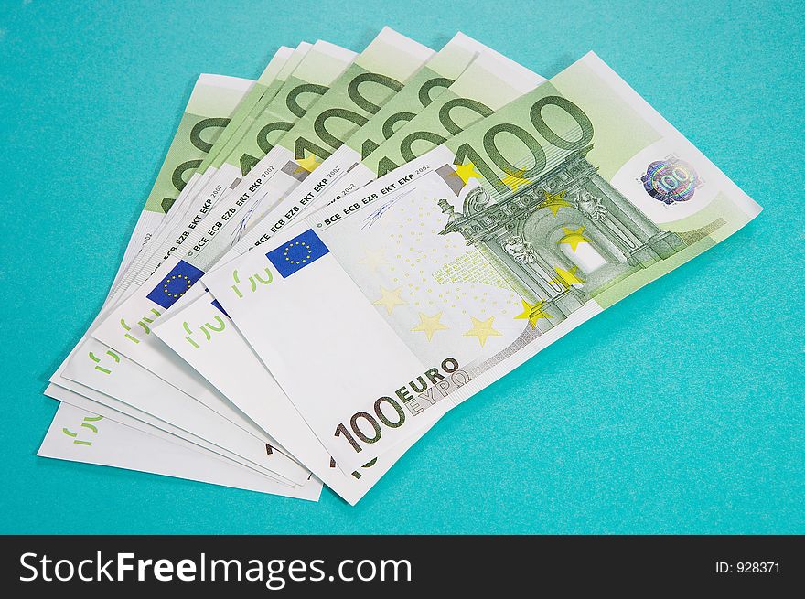 100 euro bills on turquoise background. 100 euro bills on turquoise background