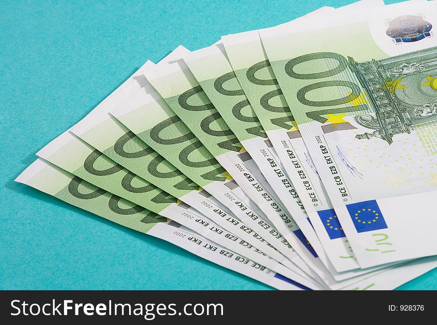 100 euro bills on turquoise background. 100 euro bills on turquoise background