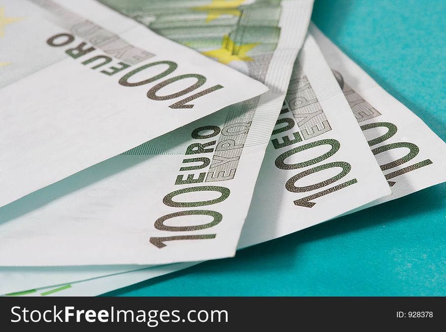 100 euro bills on turquoise background. 100 euro bills on turquoise background