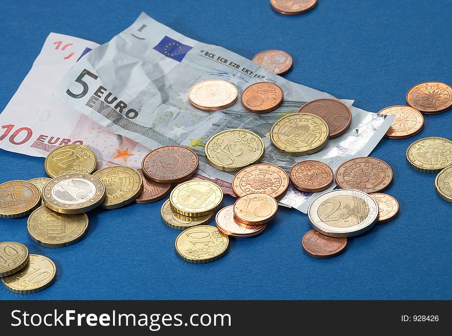 Paper money and different coins on blue background. Paper money and different coins on blue background