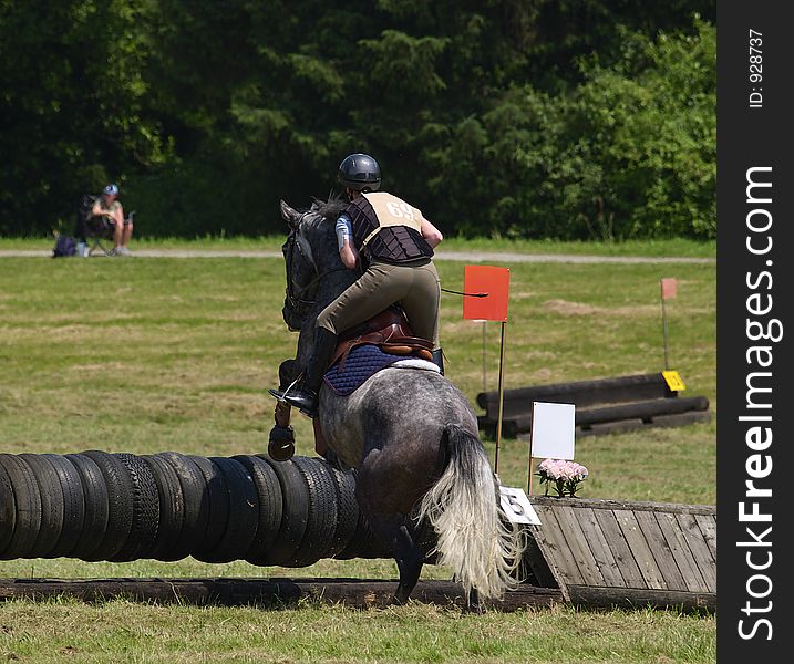 Horse and rider clearing jump in local competition. Horse and rider clearing jump in local competition