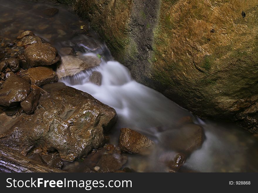 The stream runs between rocks. The stream runs between rocks