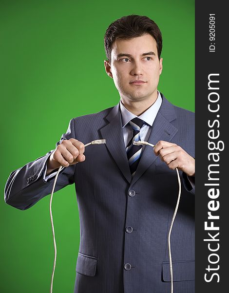 Man with wires in his hands on green background