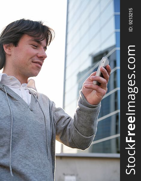 A man talking on a cell phone against the backdrop of a modern building. A man talking on a cell phone against the backdrop of a modern building