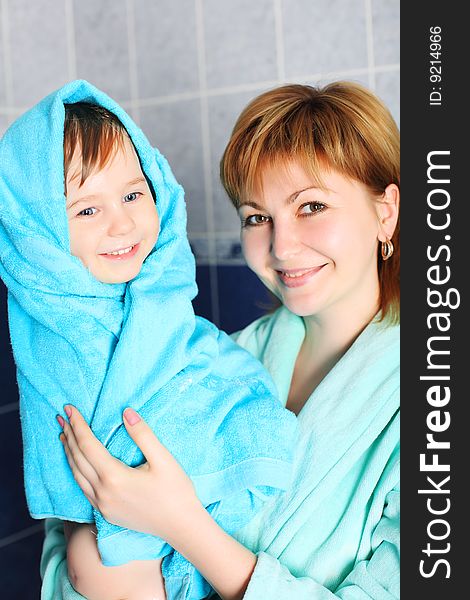 Portrait of a happy mother with her son after bath.