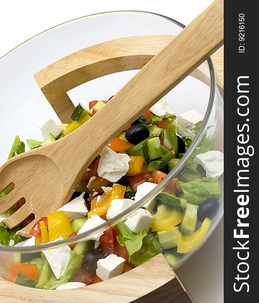 Bowl with vegetable salad and a wooden spoon