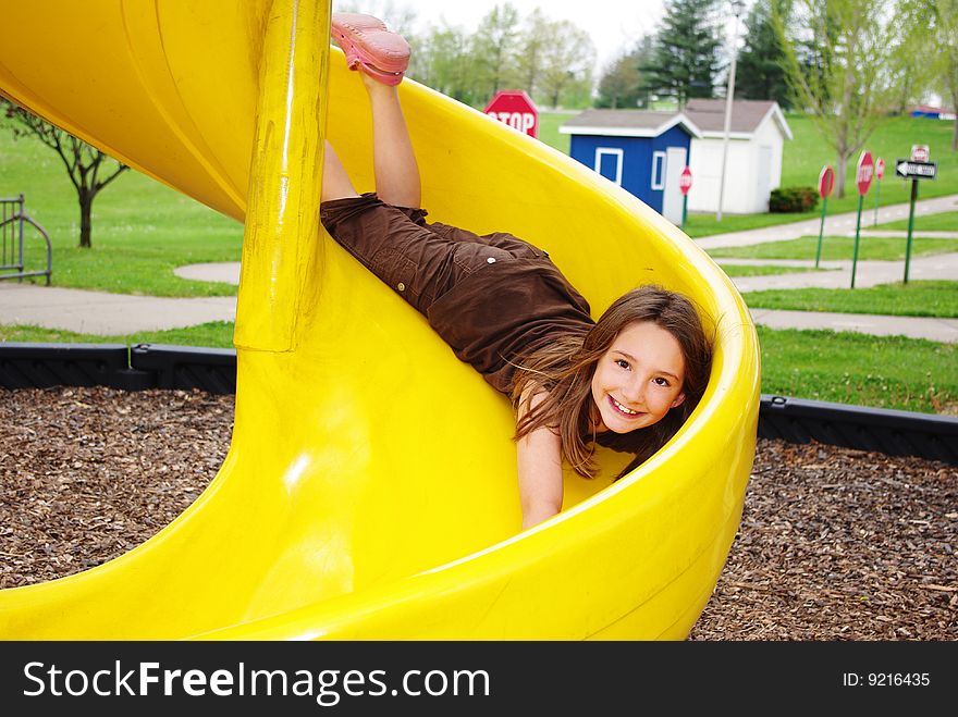 Happy little girl bellyflops on a slide. Happy little girl bellyflops on a slide
