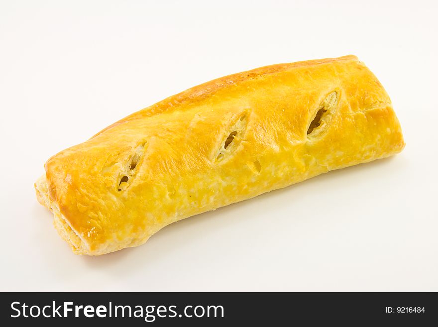 Single whole golden sausage roll on a white background. Single whole golden sausage roll on a white background