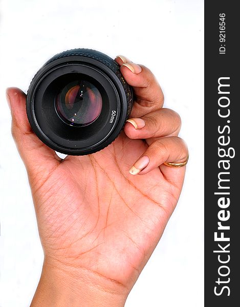 Female hand holding camera lens.