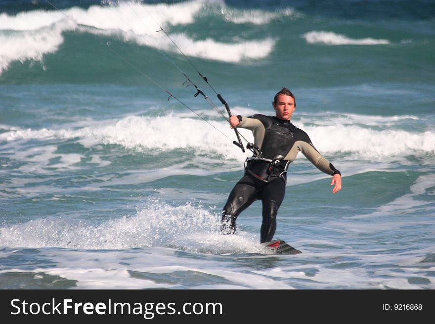 Kitesurfer surfing through the waves