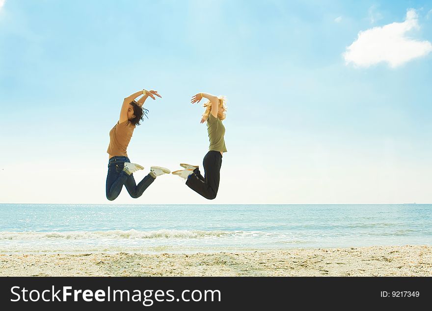 Happy young women jumping on the beach. Happy young women jumping on the beach