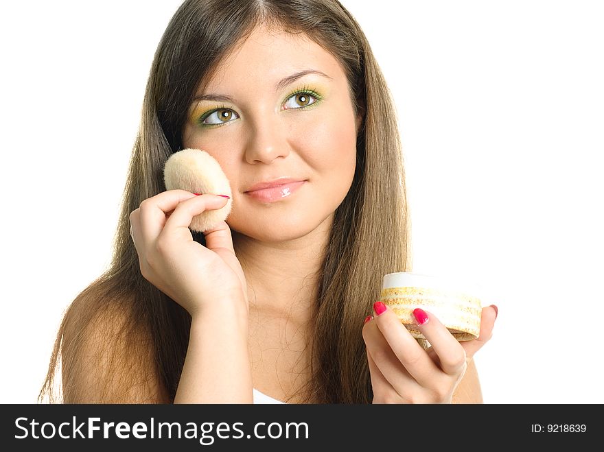 Beautiful young woman applying powder with a sponge