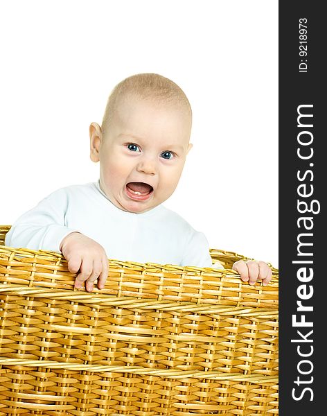 Cute six months old displeased baby boy sitting in the basket