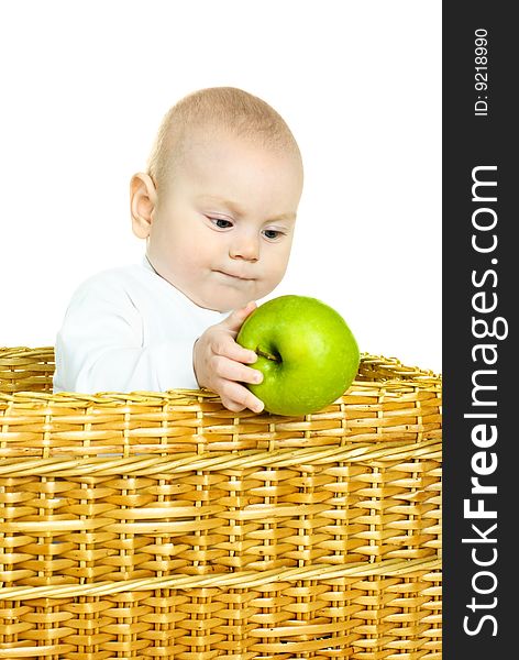 Cute six months old baby boy sitting in the basket and holding a green apple. Cute six months old baby boy sitting in the basket and holding a green apple